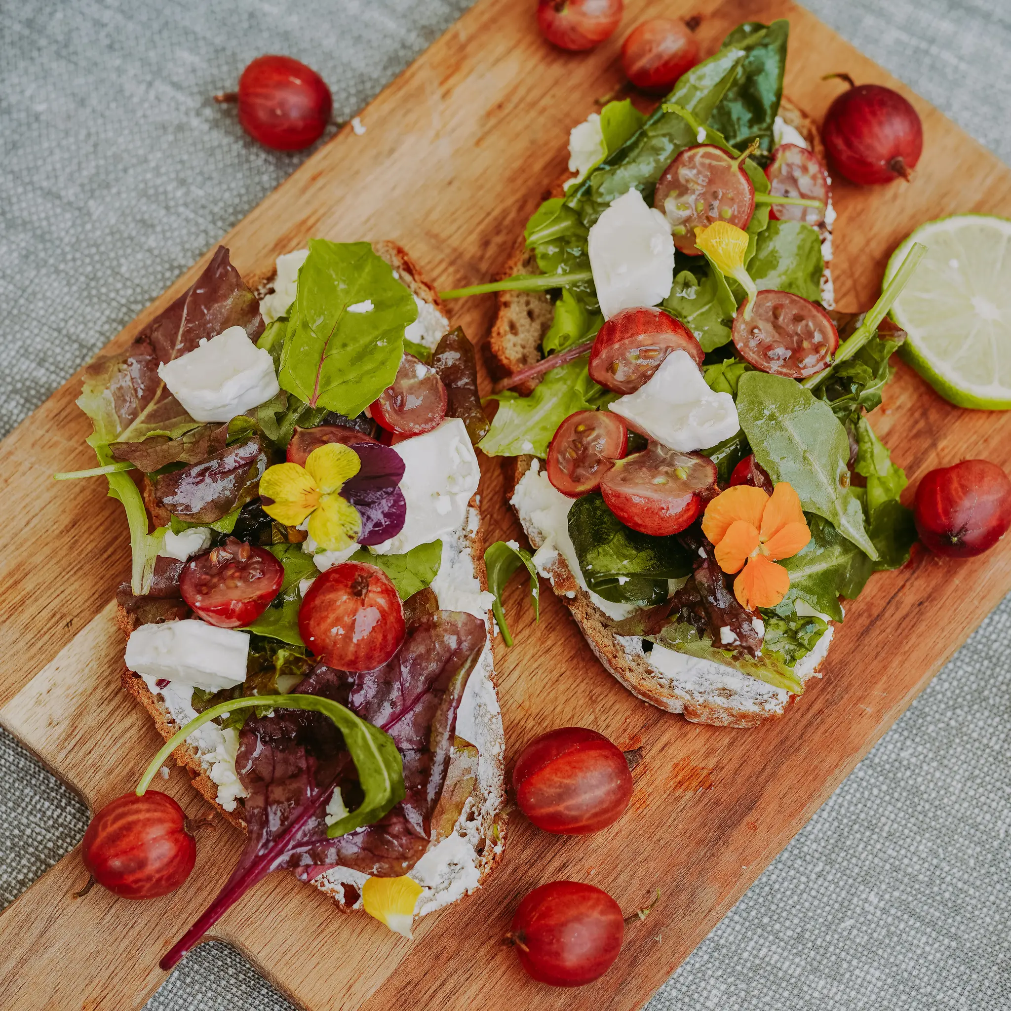 Frisches Brot belegt mit buntem Gemuese und Fetakaese