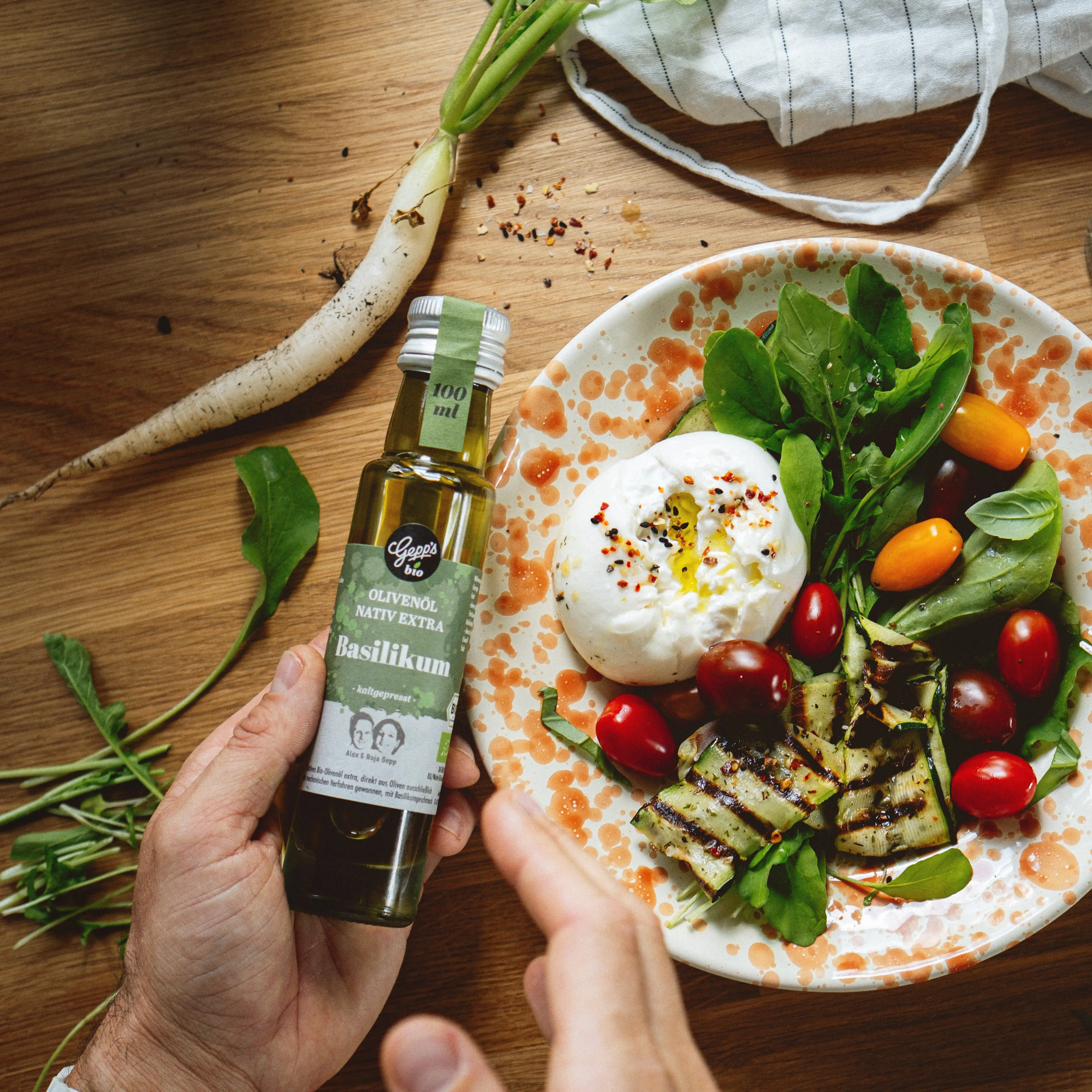 Feines Olivenoel Basilikum auf Burrata und buntem Salat