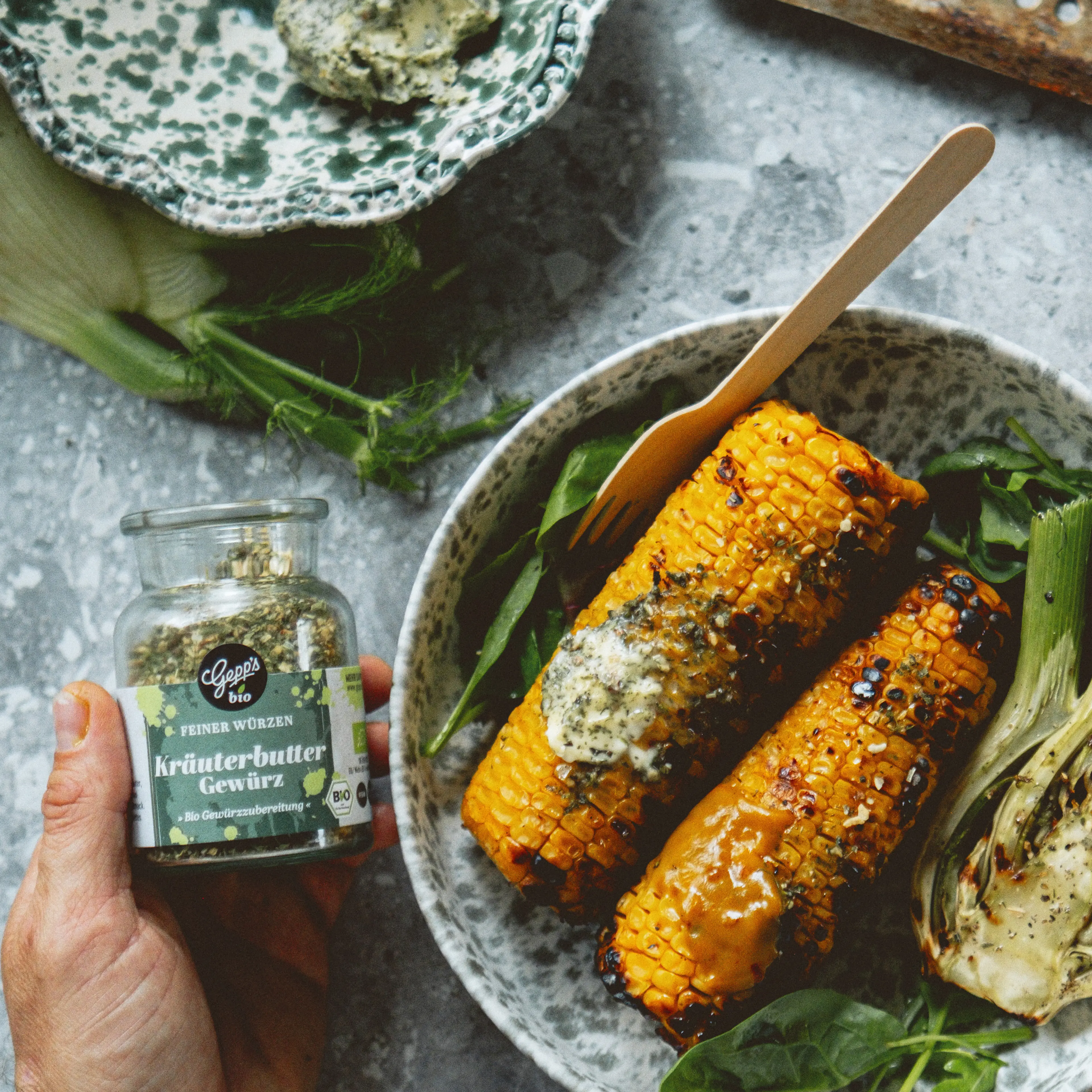 Hausgemachte Kraeuterbutter mit Kraeuterbutter Gewuerz auf gegrilltem Maiskolben